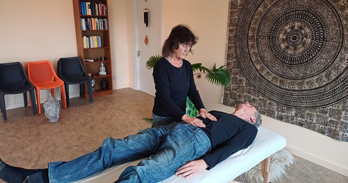 Jolanda Verburg geeft een reiki behandeling in de studio in Beusichem